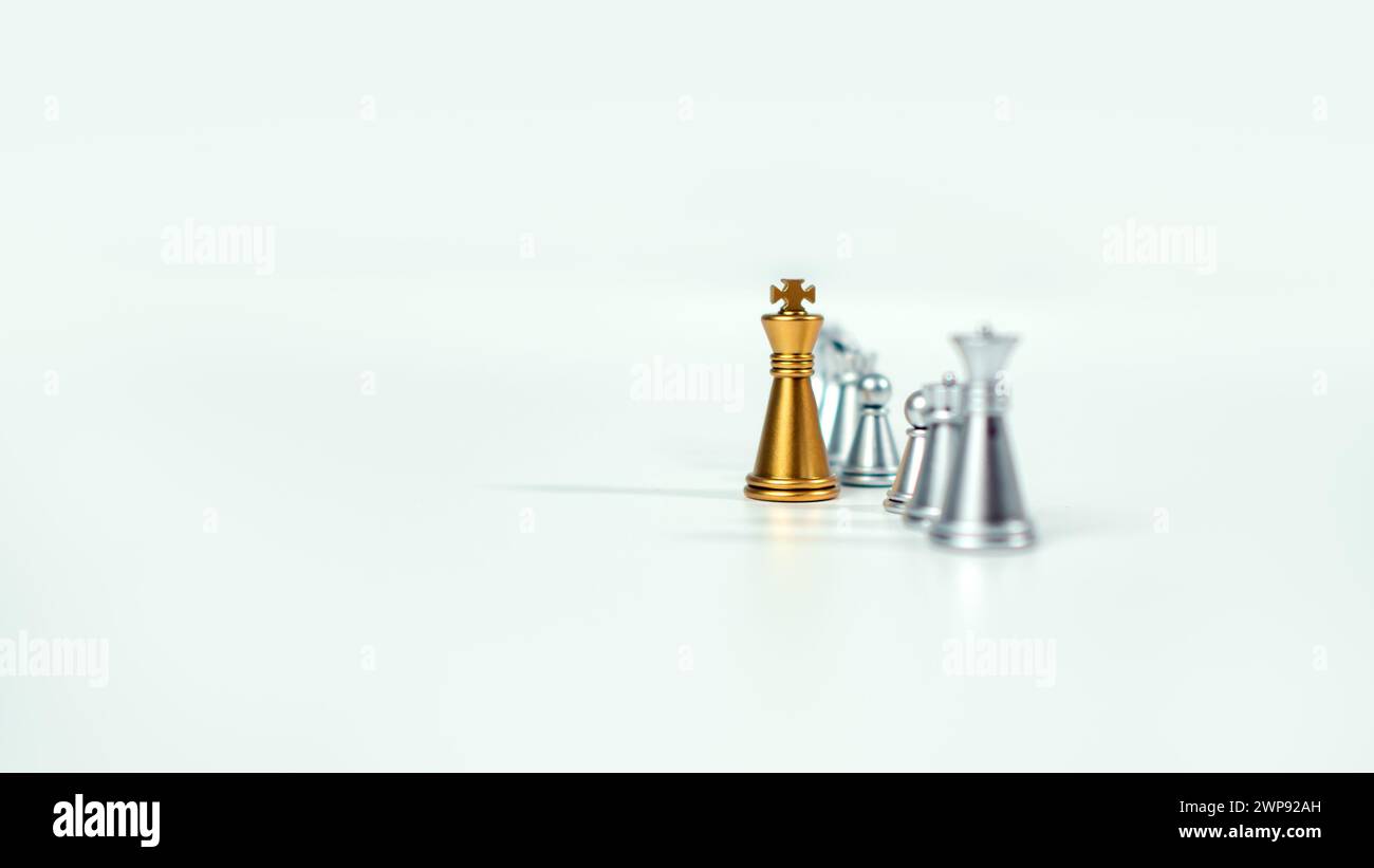 Échecs de roi d'or sur le tableau devant des pièces d'échecs en argent sur fond blanc avec espace de copie, leadership, combattant, direction des affaires, concurrent Banque D'Images