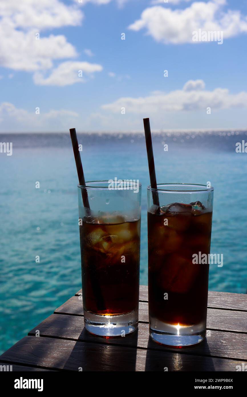 Boissons glacées contre eau de mer turquoise et ciel bleu dans les Caraïbes Banque D'Images