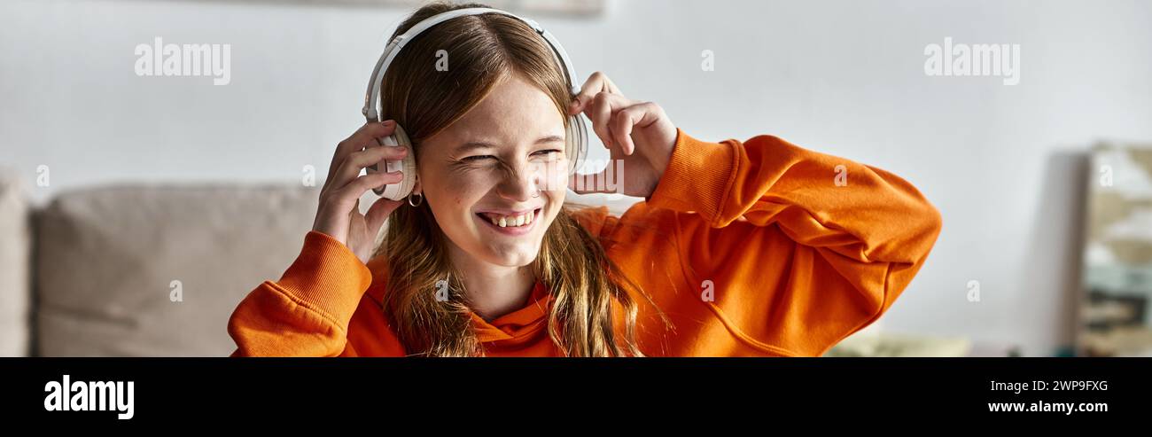 Jeune fille joyeuse dans des écouteurs blancs sans fil appréciant la musique à la maison, bannière horizontale Banque D'Images
