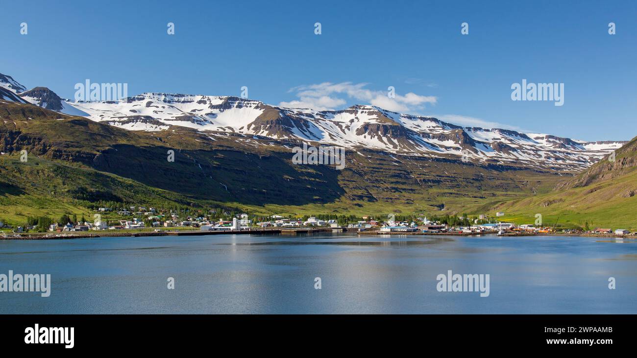 Vue sur le port et la ville de Seyðisfjörður le long du fjord Seydisfjoerdur en été, région orientale / Austurland, Islande Banque D'Images