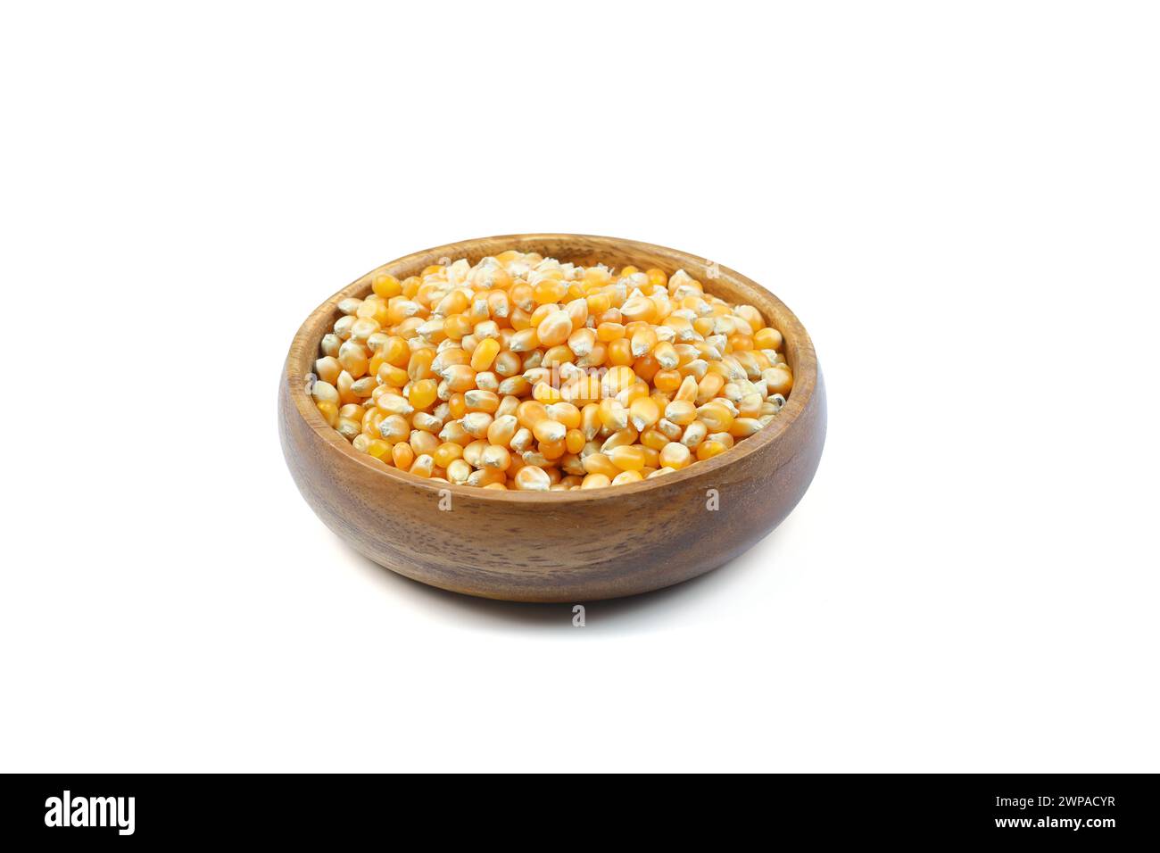 Pop-corn non éclaté dans un bol en bois sur fond blanc. Type de maïs qui se dilate à partir du grain et gonfle lorsqu'il est chauffé. Graines jaunes, comestibles, crues Banque D'Images
