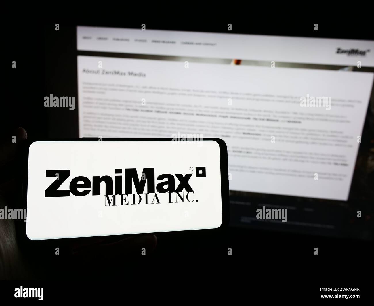 Personne tenant un smartphone avec le logo de la société américaine de jeux vidéo ZeniMax Media Inc en face du site Web. Concentrez-vous sur l'affichage du téléphone. Banque D'Images Personne tenant un smartphone avec le logo de la société américaine de jeux vidéo ZeniMax Media Inc en face du site Web. Concentrez-vous sur l'affichage du téléphone. Banque D'Images