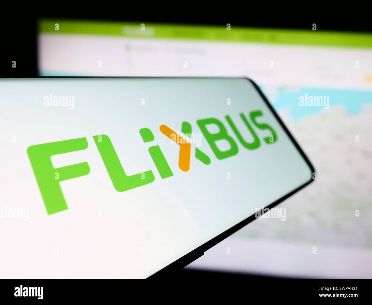 Smartphone avec logo de la compagnie allemande de transport par bus longue distance FlixBus en face du site Web de l'entreprise. Focus à gauche de l'écran du téléphone. Banque D'Images