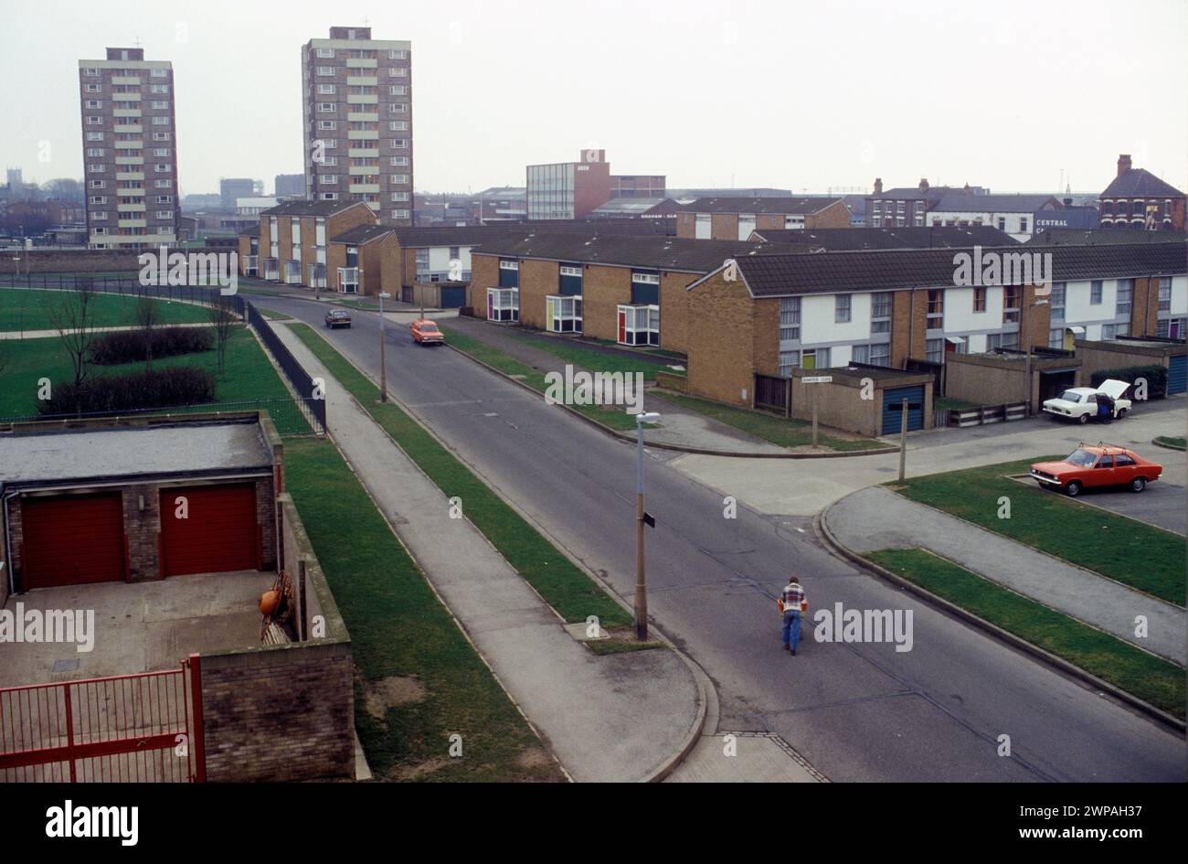 1980s nouveau lotissement dans le quartier de Hessle Road de la ville. Un homme solitaire traversant Walker Street vers Quantock Close, Hull, Humberside, Angleterre 1980. HOMER SYKES Banque D'Images