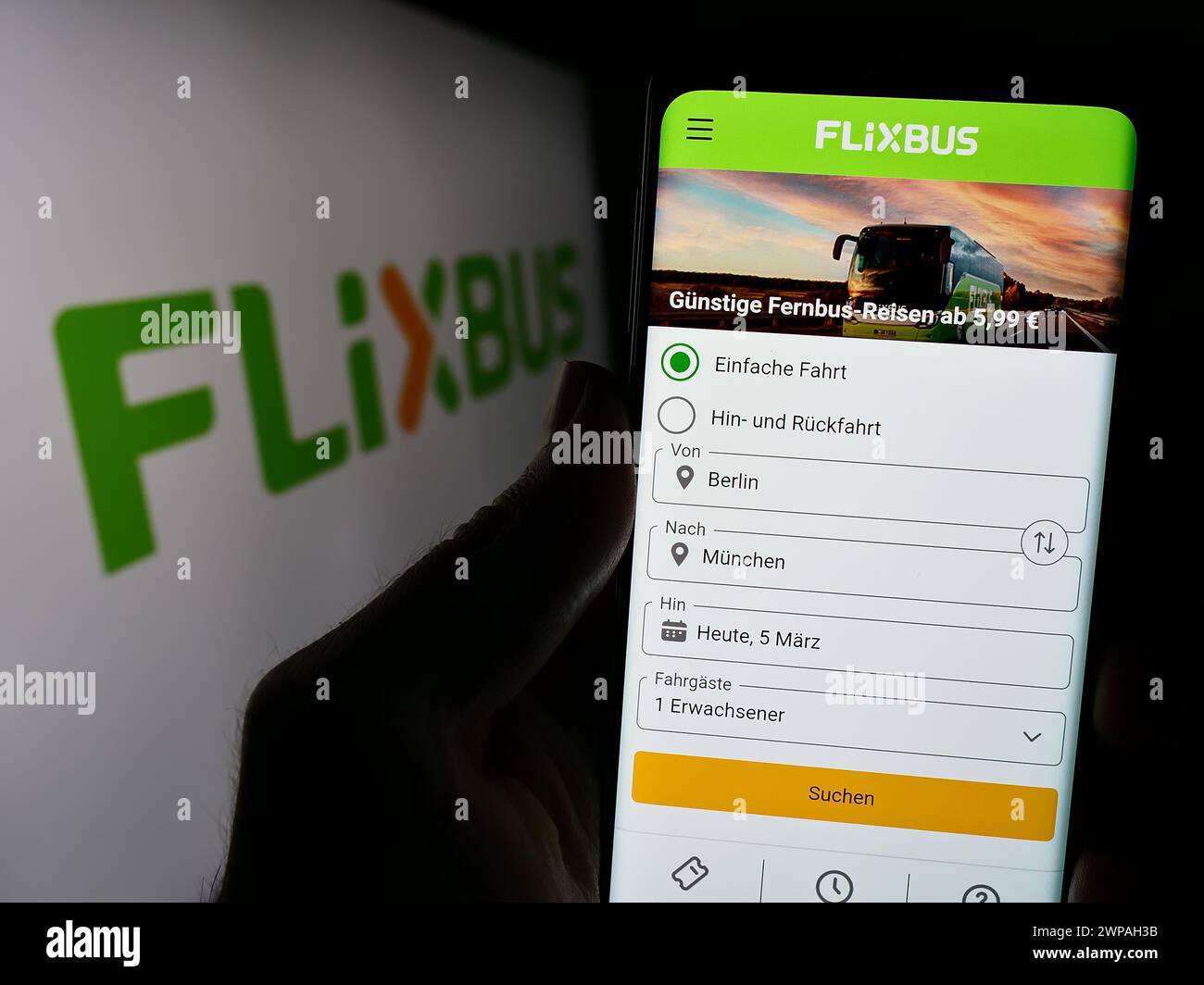Personne tenant le téléphone portable avec la page Web de la compagnie allemande de transport de bus longue distance FlixBus devant le logo. Concentrez-vous sur le centre de l'écran du téléphone. Banque D'Images