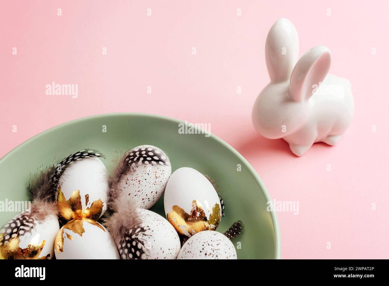 Disposition de Pâques avec assiette d'oeufs de Pâques et lapin sur table rose. Vue de dessus. Banque D'Images