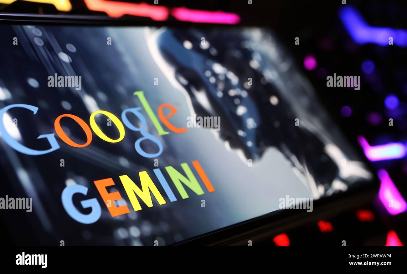Viersen, Allemagne - 9 février. 2024 : gros plan de l'écran du smartphone avec le lettrage du logo de Google Gemini sur le clavier de l'ordinateur Banque D'Images