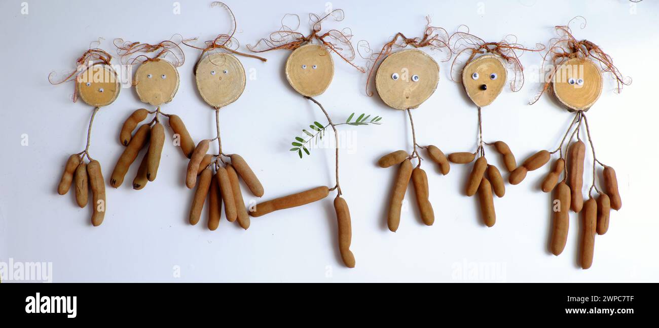 Décoration drôle faire blague mannequin de tamarin, corps de fruit, cheveux de fil avec des yeux, art alimentaire créatif sur blanc Banque D'Images