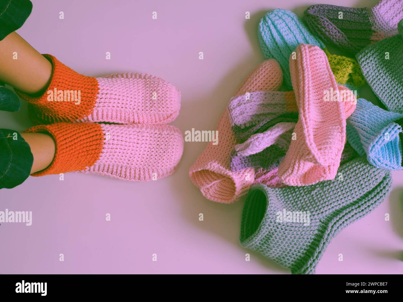 Femme porter des bottes en laine faites à la main, chaussettes, pantoufles au crochet à partir de fil pour faire des chaussures chaudes pour l'hiver à partir d'un groupe de nombreux à la main fait confortable Banque D'Images