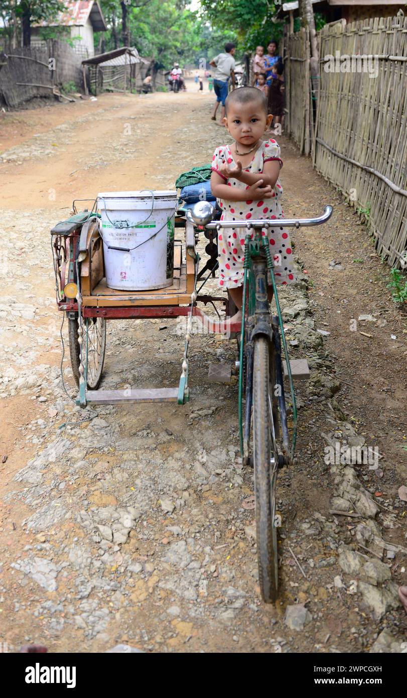 Une jolie fille arakanaise assise sur un vélo à Mrauk-U, État de Rakhine, Myanmar. Banque D'Images