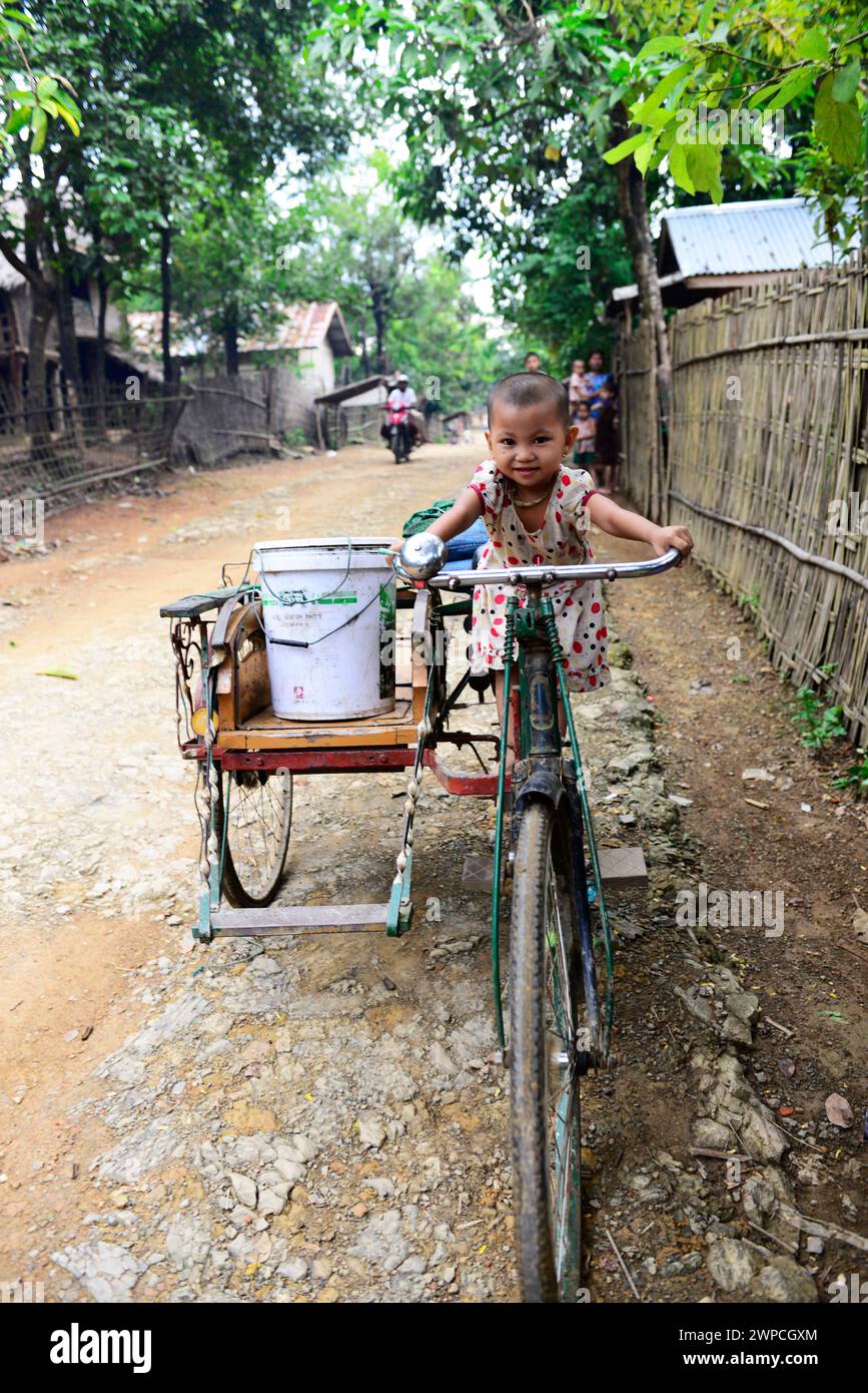 Une jolie fille arakanaise assise sur un vélo à Mrauk-U, État de Rakhine, Myanmar. Banque D'Images
