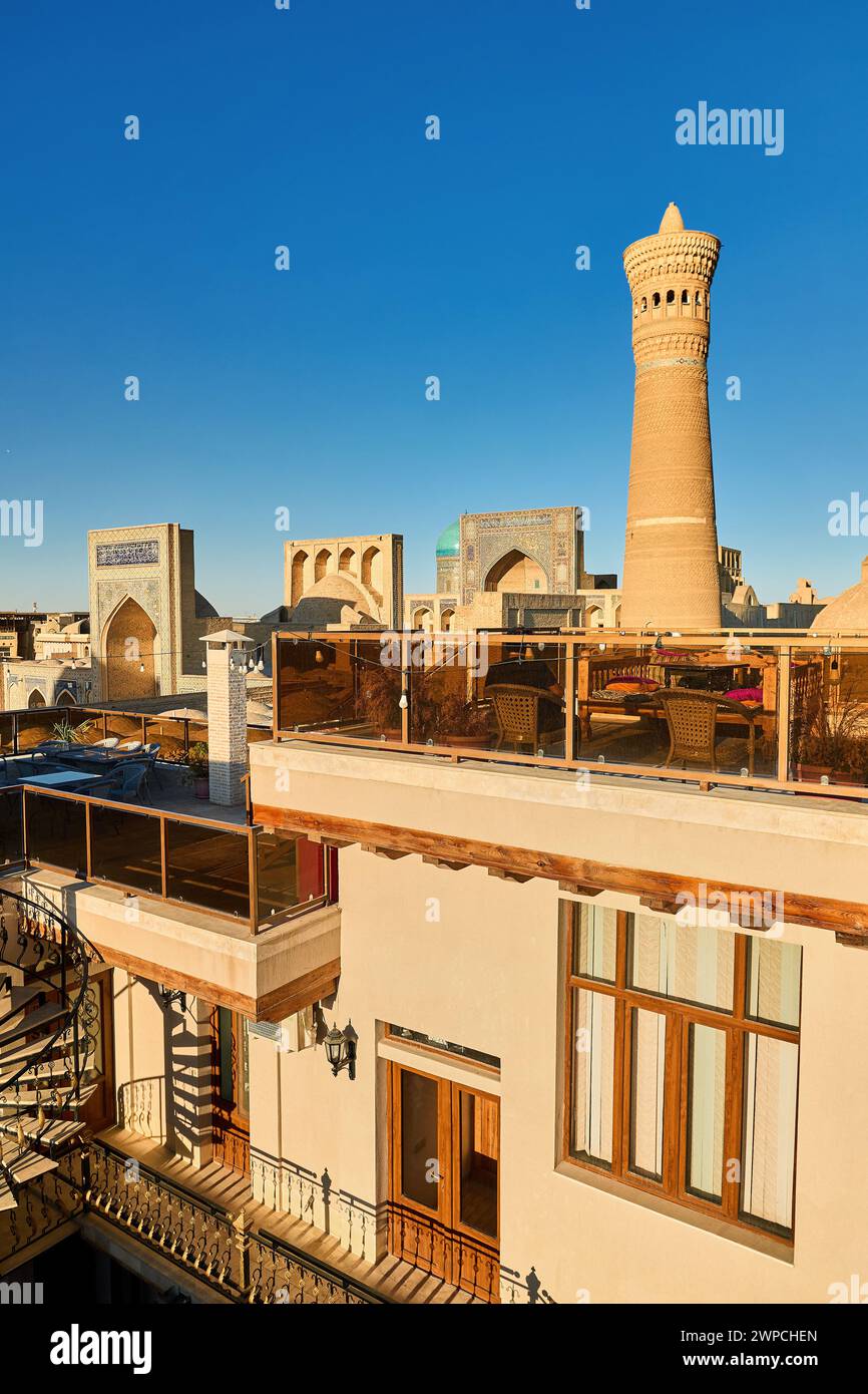 Restaurant sur le toit avec lit de table topchan à Boukhara près de Kalyan Minaret et madrasah en Ouzbékistan Banque D'Images Restaurant sur le toit avec lit de table topchan à Boukhara près de Kalyan Minaret et madrasah en Ouzbékistan Banque D'Images