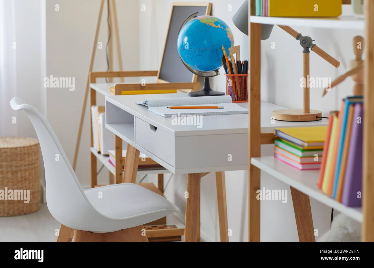 Salle d'étude moderne pour enfants avec bureau, chaise, étagères, livres, crayons, lampe et globe Banque D'Images