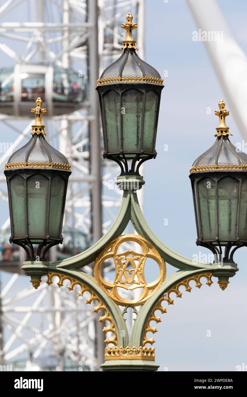 Royaume-Uni, Londres, détails de la lampe en fer forgé sur le pont de Westminster avec Millennium Wheel en arrière-plan. Banque D'Images