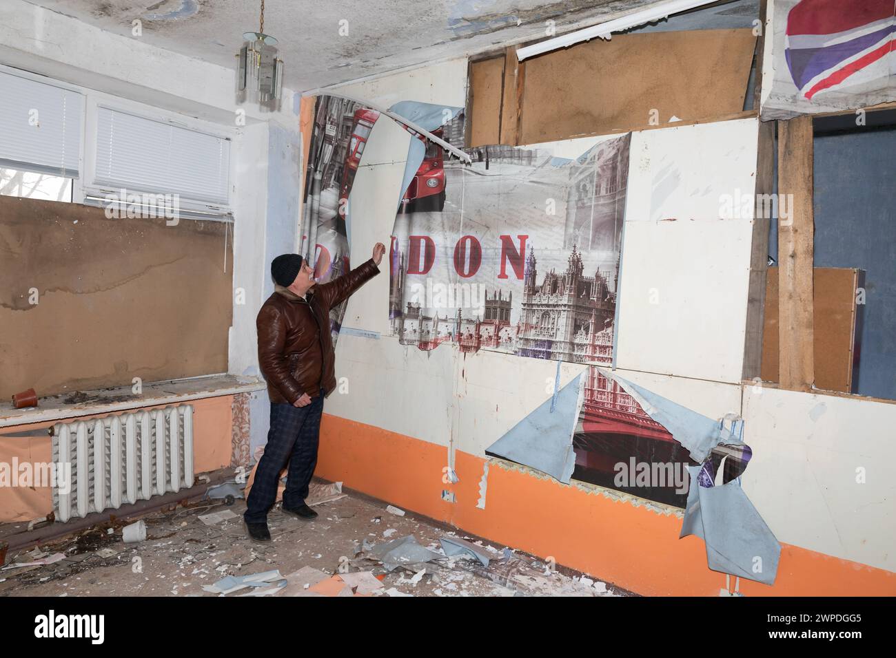 MYKOLAIV Reg, UKRAINE - 01 mars 2024 : guerre en Ukraine. Homme dans une salle de classe anglophone montrant des destructions à la suite d'attaques à la roquette et à l'artillerie contre l'école dans le village de Chervona Dolyna Banque D'Images