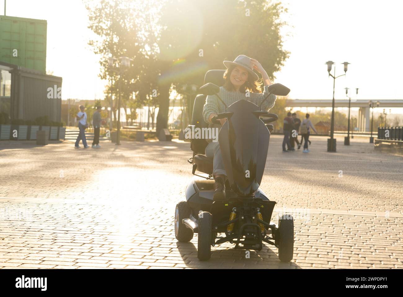 Femme touriste chevauchant un scooter électrique de mobilité à quatre roues sur une rue de la ville.. Banque D'Images