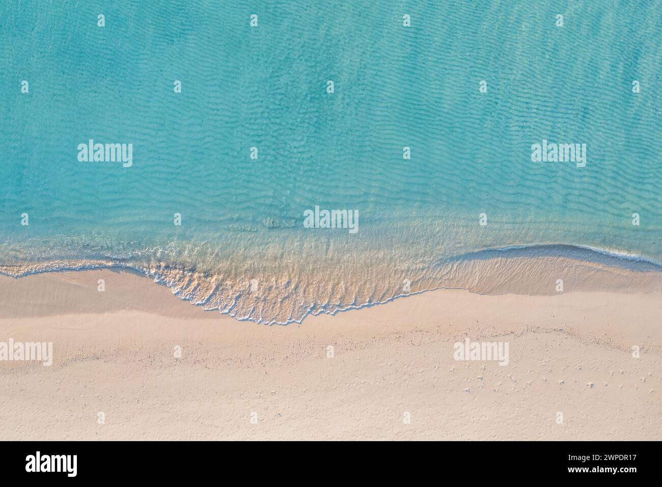 Scène de plage aérienne relaxante. Bannière de destination de vacances d'été. Les vagues de surf écrasent un étonnant lagon bleu de l'océan, rivage de la mer, littoral tranquille Banque D'Images