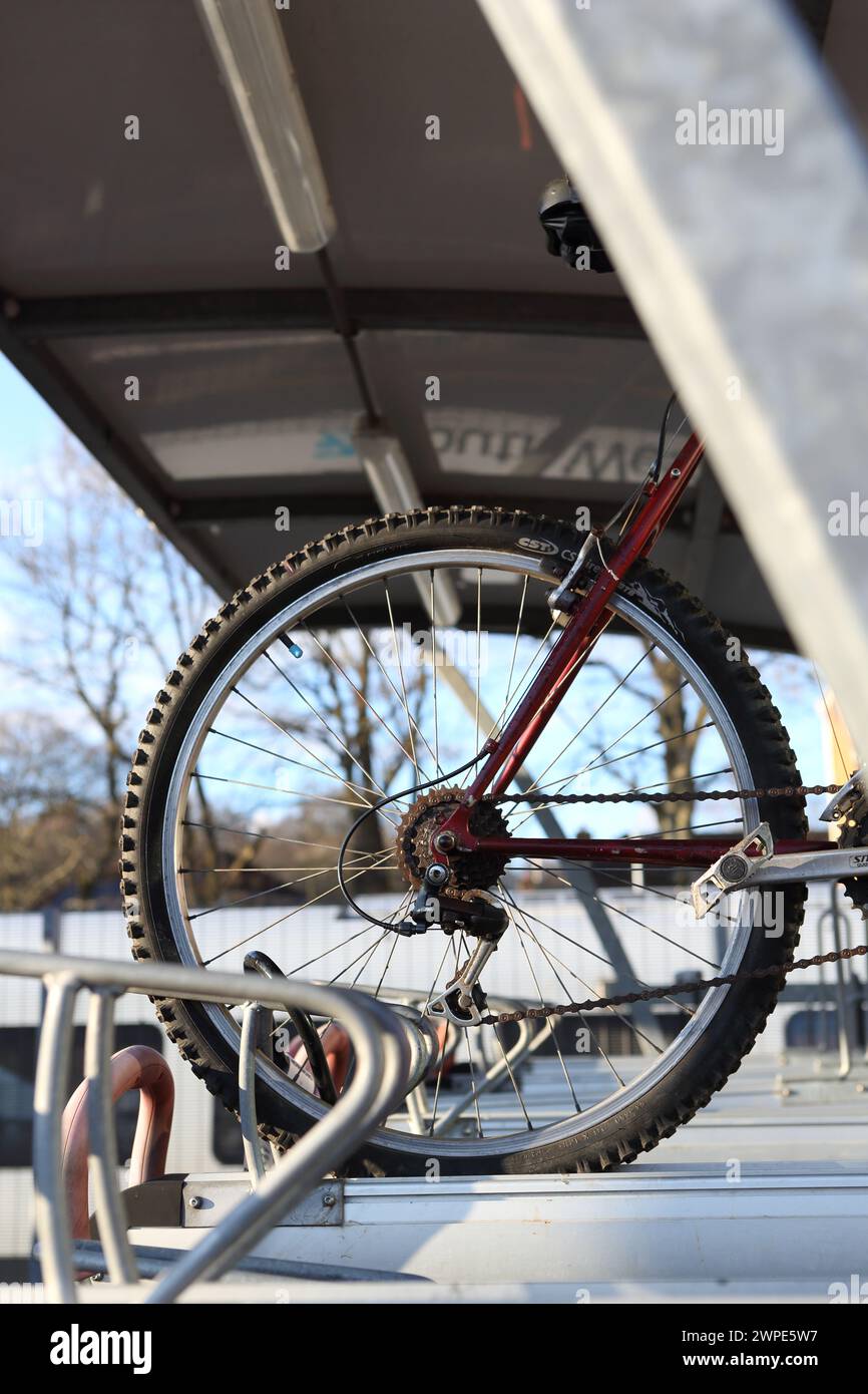 Roue de vélo arrière avec des équipements de stationnement de vélos à Farnborough gare principale avec porte-vélos, Farnborough, Hampshire, Royaume-Uni Banque D'Images