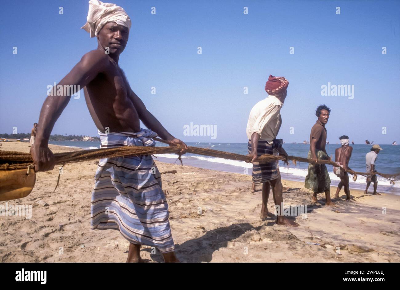 Sri Lanka, sur la plage de Galle, les hommes tirent des filets de pêche hors de la mer. Banque D'Images