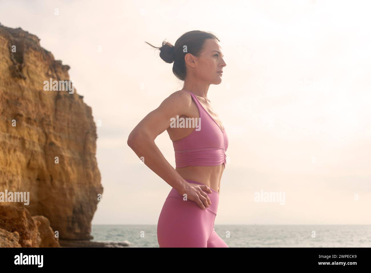 femme portant des vêtements de sport debout au bord de la mer. Préparation avant la baignade en eau libre Banque D'Images femme portant des vêtements de sport debout au bord de la mer. Préparation avant la baignade en eau libre Banque D'Images