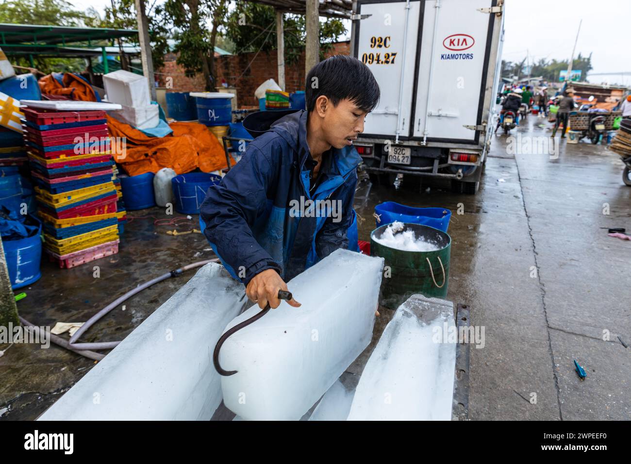 Ouvrier avec des blocs de glace au marché aux poissons de Hoi an Banque D'Images