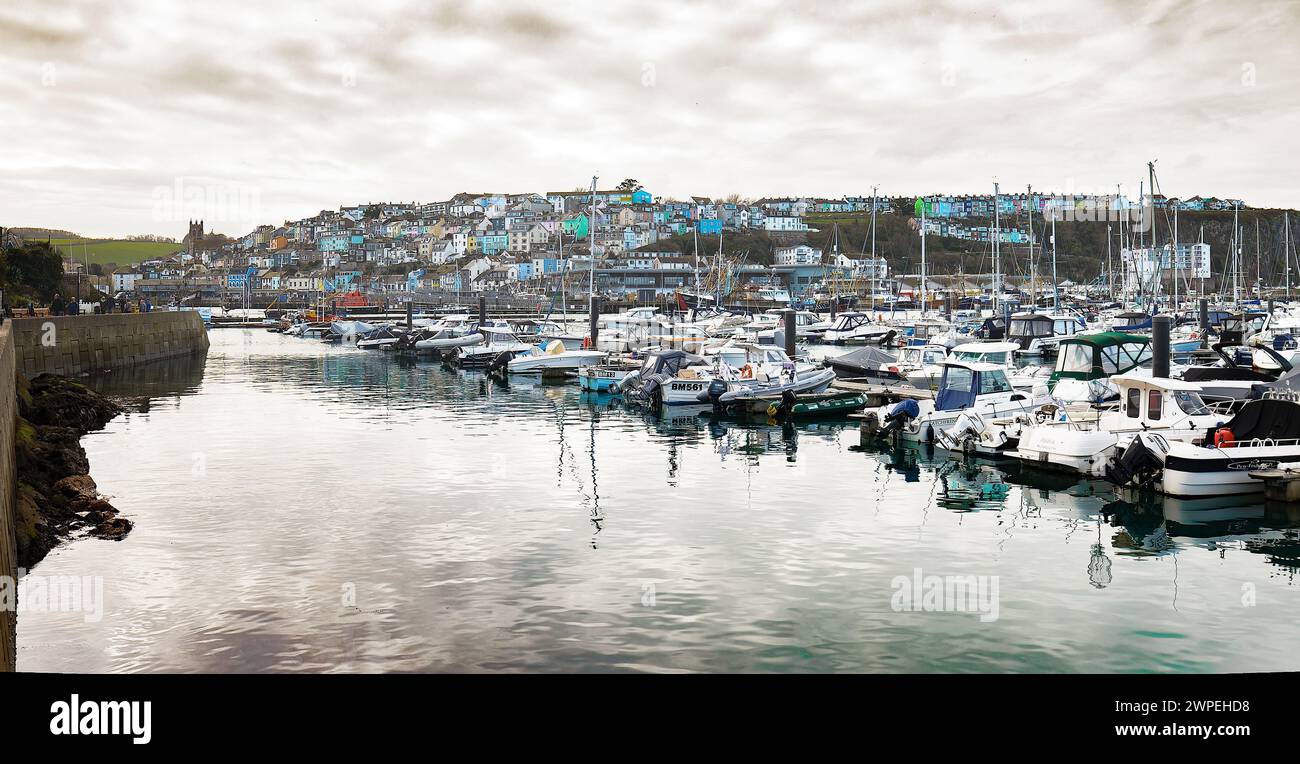 Brixham Marina montrant des yachts avec des mâts et Brixham Town avec des maisons multicolores et une passerelle autour de la marina, en hiver Banque D'Images