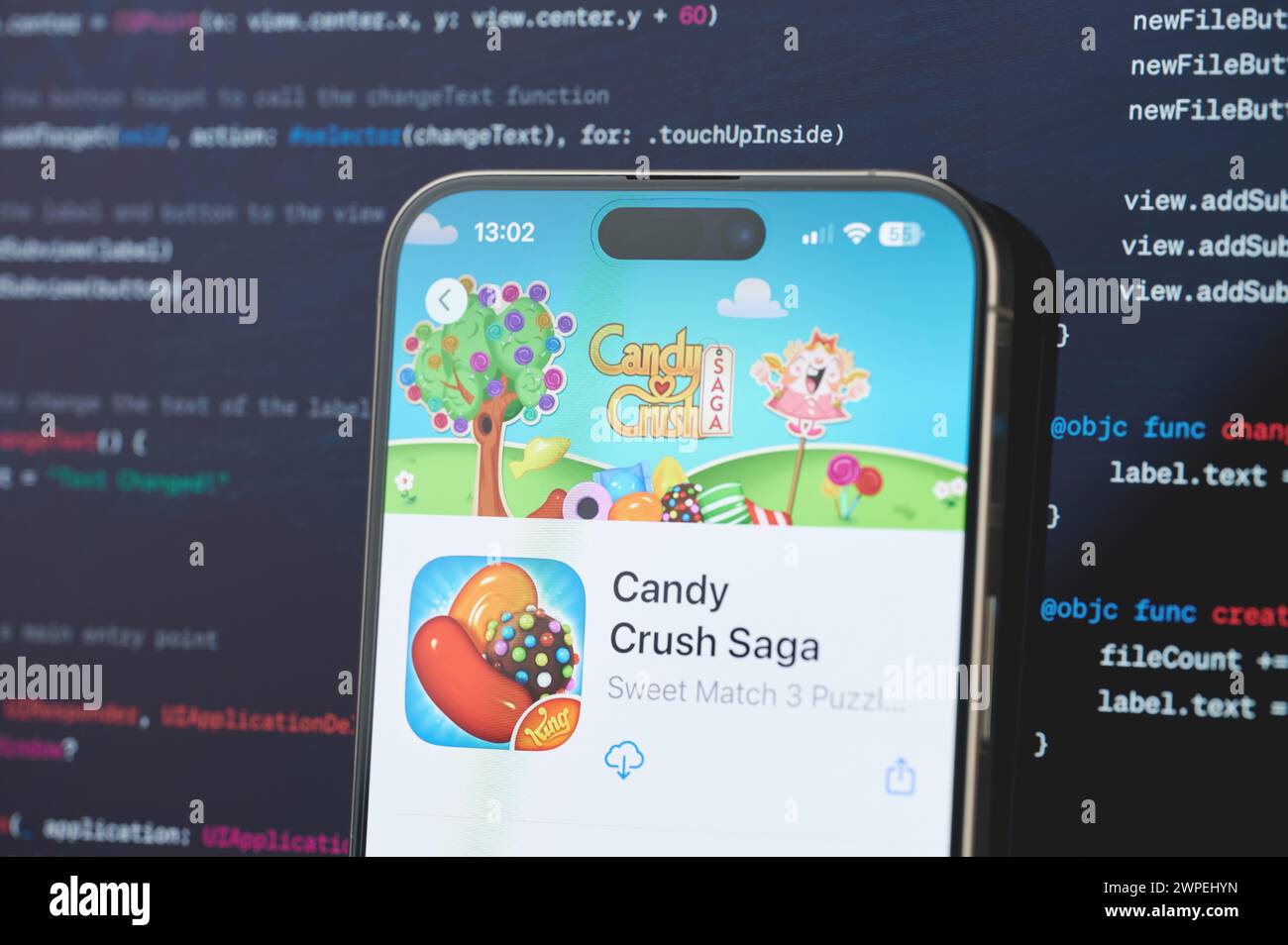 New York, États-Unis - 23 février 2024 : jeu T Candy Crush Saga sur l'écran de l'iphone en arrière-plan de programmation de code flou Banque D'Images