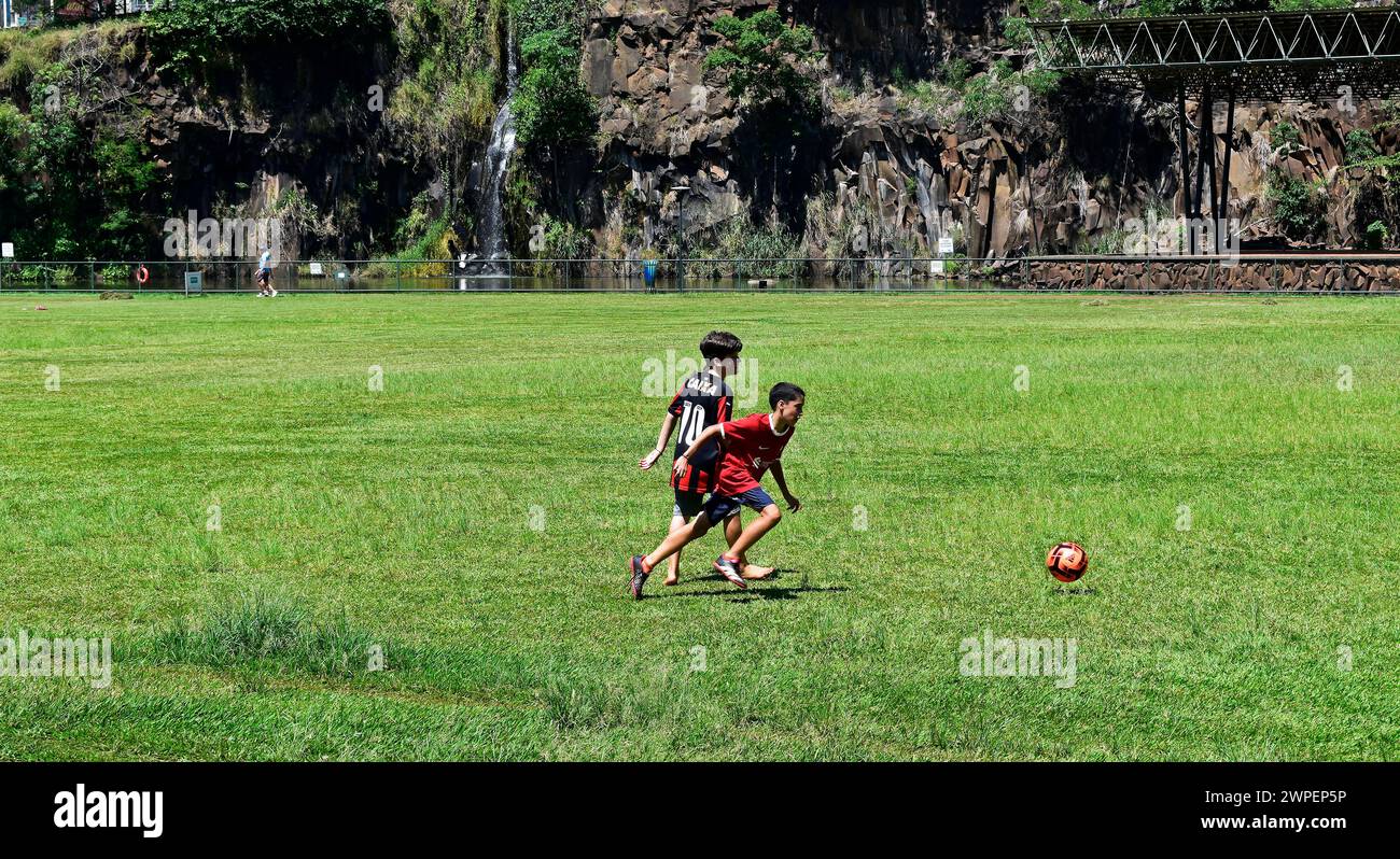 RIBEIRAO PRETO, SAO PAULO, BRÉSIL - 26 décembre 2023 : deux enfants jouant au ballon dans un parc public Banque D'Images