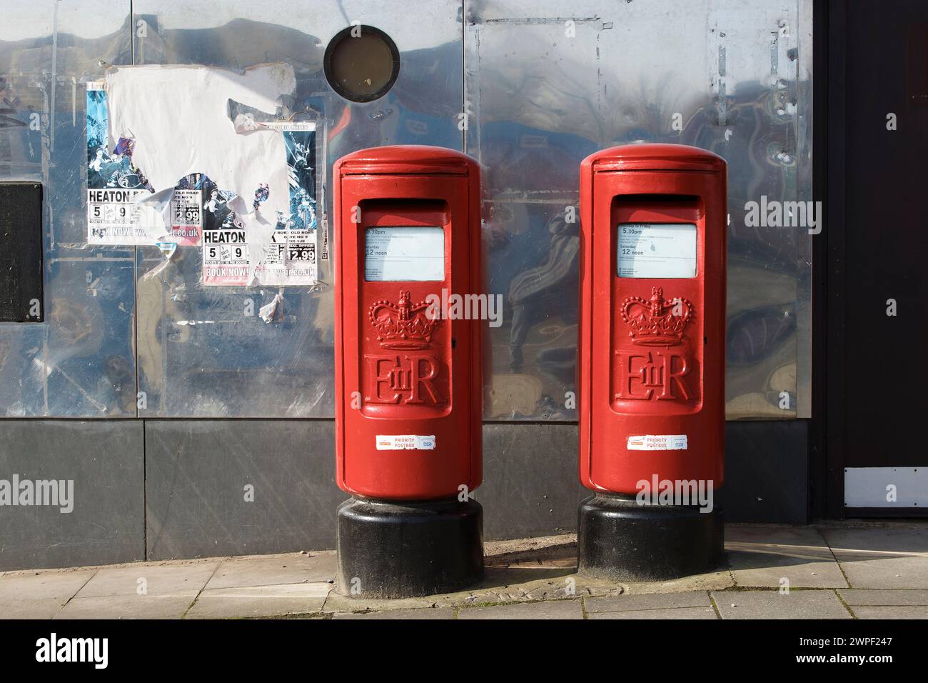 Deux boîtes postales rouges sur le trottoir, er 11 et Crown, avec un mur métallique derrière, à radcliffe près de Bury Greater manchester uk Banque D'Images