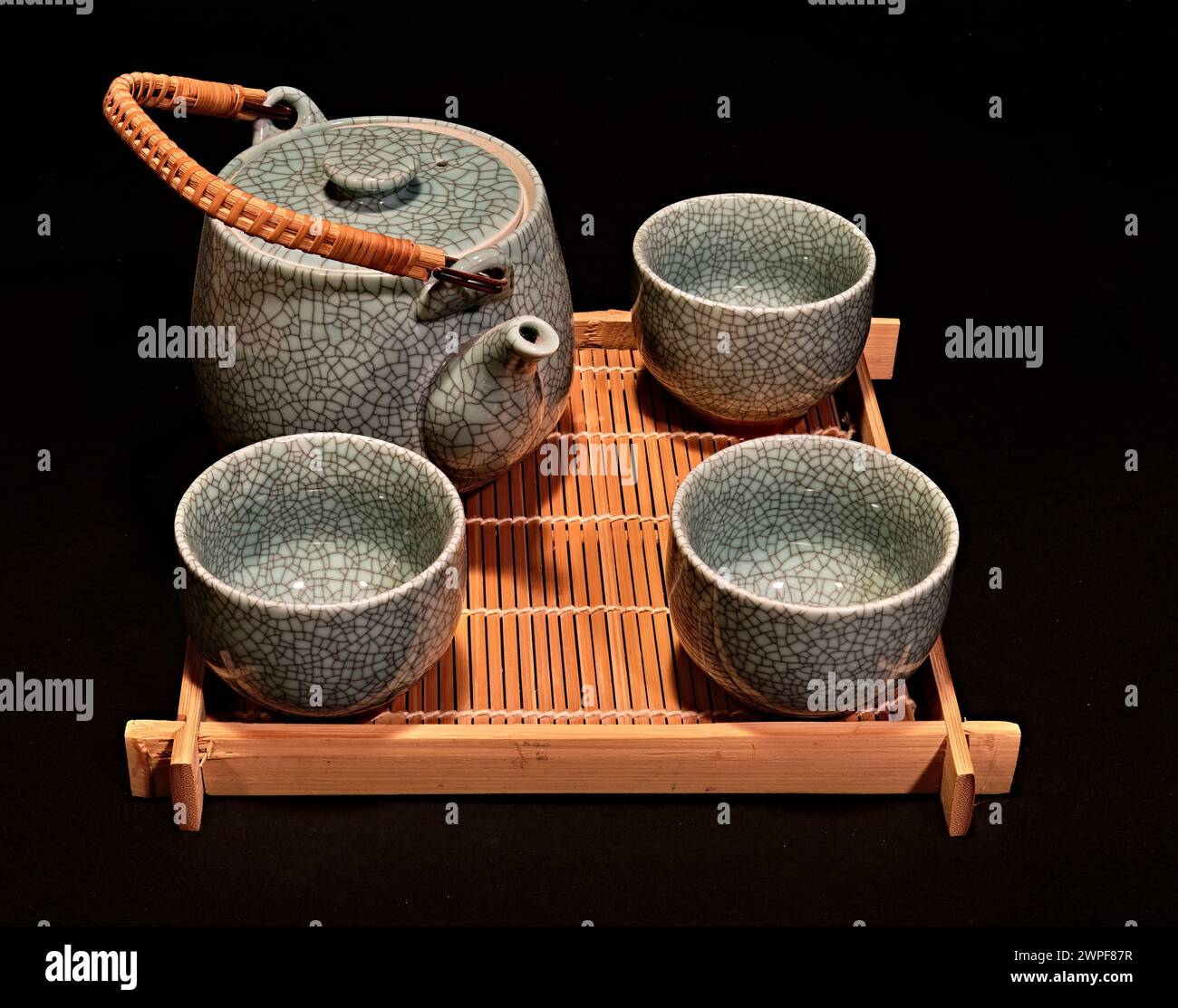 Une nature morte d'un service de thé chinois de cérémonie en céramique, japonais. Sur un plateau en bambou,avec un fond noir. Banque D'Images