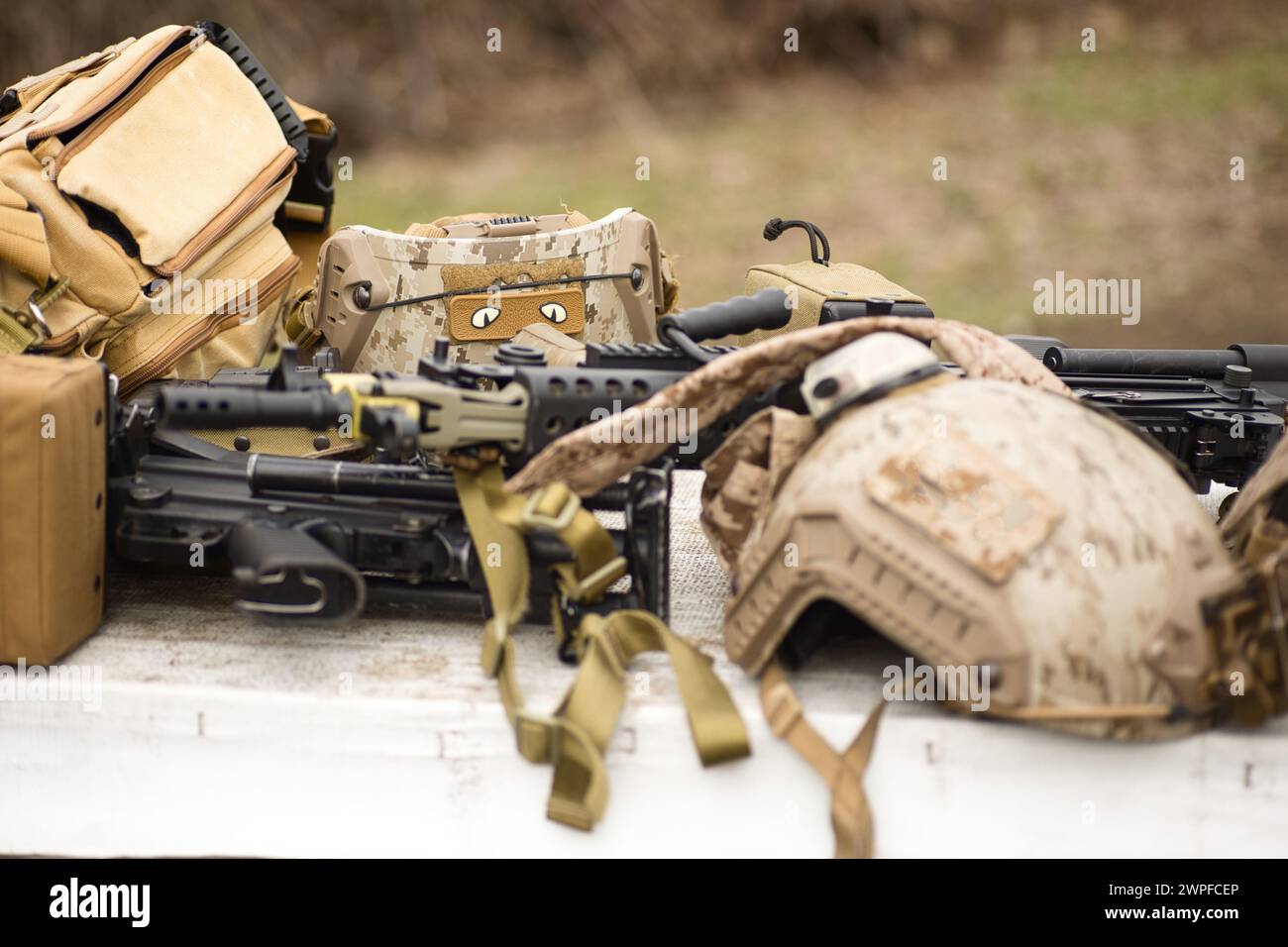 Arme de réplique Airsoft et casque de camouflage supérieur AOR 1, mitrailleuse sur un fond naturel Banque D'Images