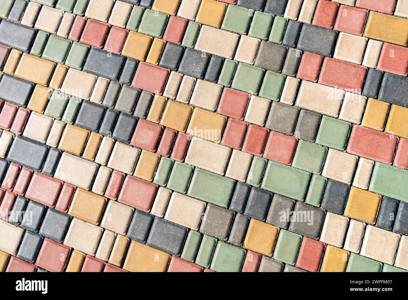 Trottoir coloré le jour ensoleillé dans le parc public. Pavés colorés dans la conception d'aménagement paysager de parc urbain comme arrière-plan Banque D'Images