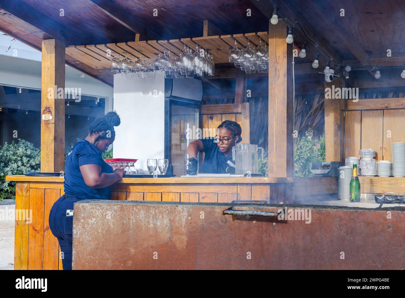 Vue rapprochée de deux serveurs afro-américains dans un restaurant barbecue en plein air. Willemstad. Curaçao. Banque D'Images