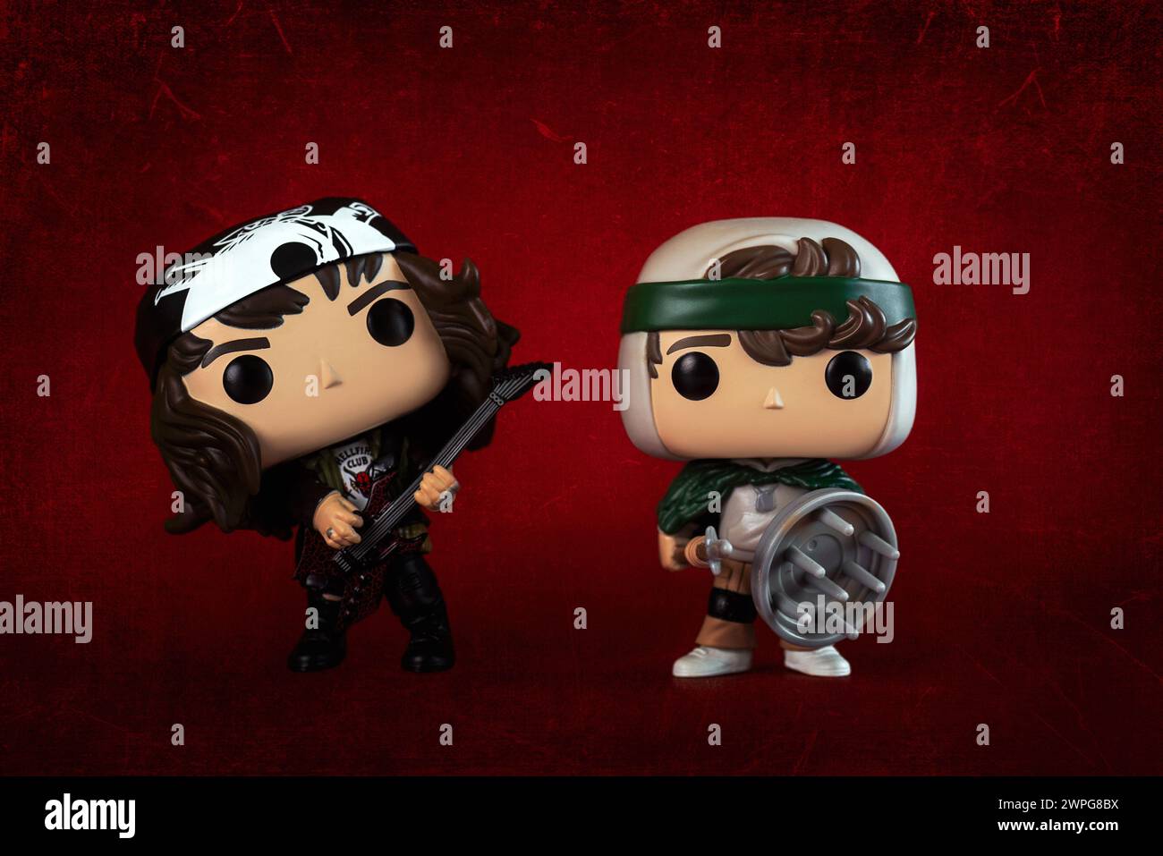 Funko figurines POP vinyle d'Eddie Munson et Dustin Henderson personnages de la série télévisée Stranger Things sur fond rouge. Éditorial illustratif o Banque D'Images