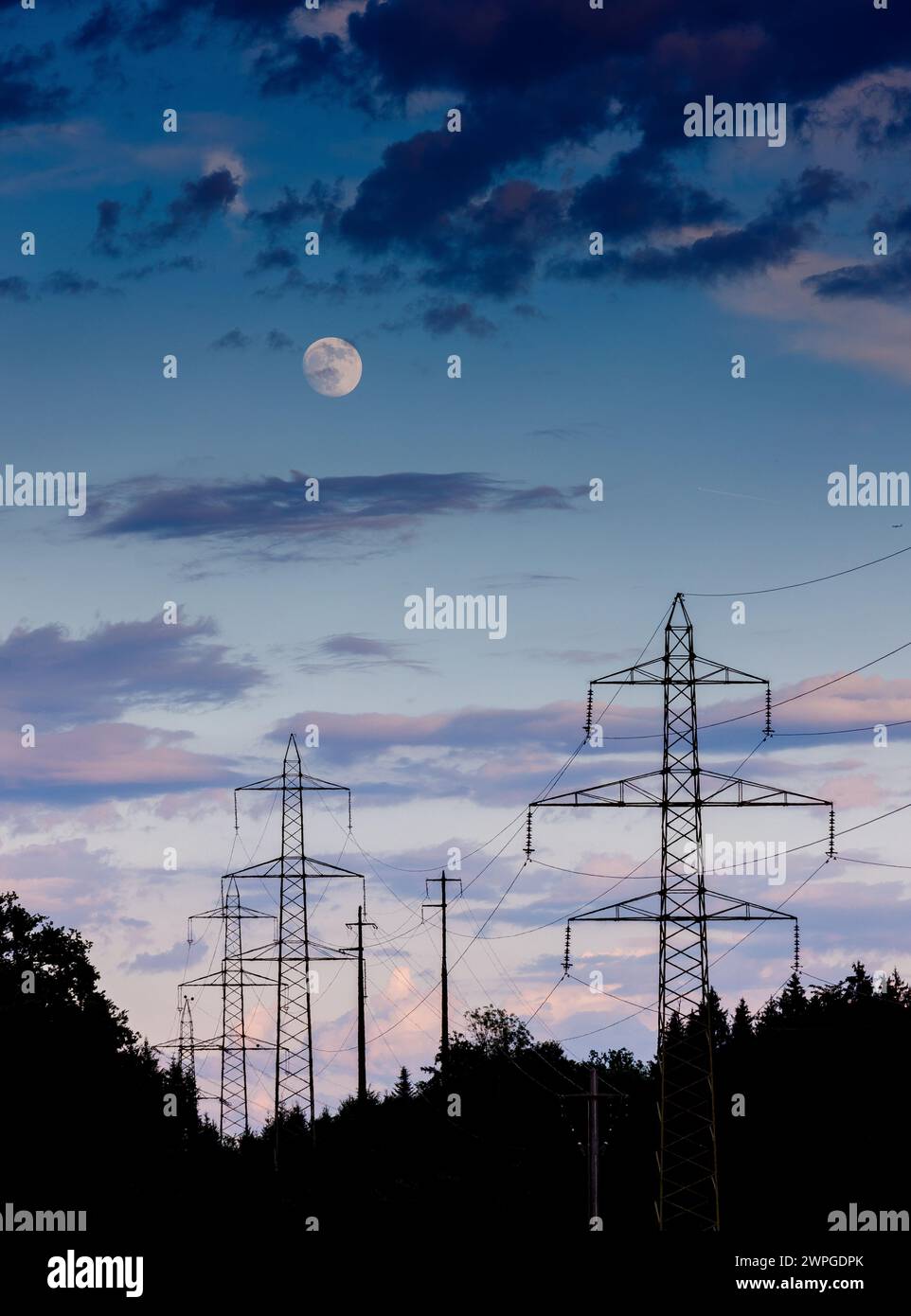 Pylônes électriques dans la lumière du soir avec lune Banque D'Images