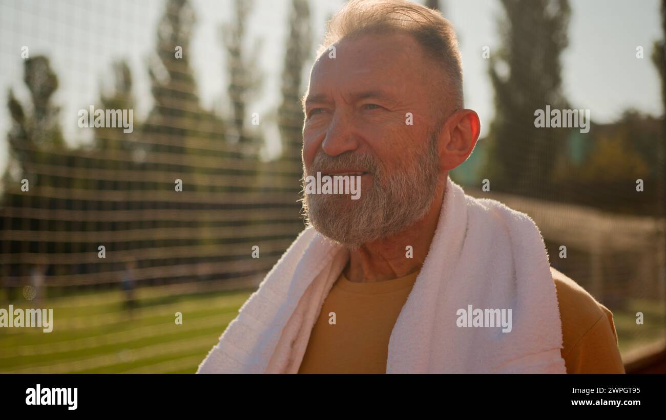 Gros plan caucasien homme âgé européen avec cou de serviette marcher stade de ville à l'extérieur après l'entraînement de sport dur exercice de soins de santé style de vie Banque D'Images