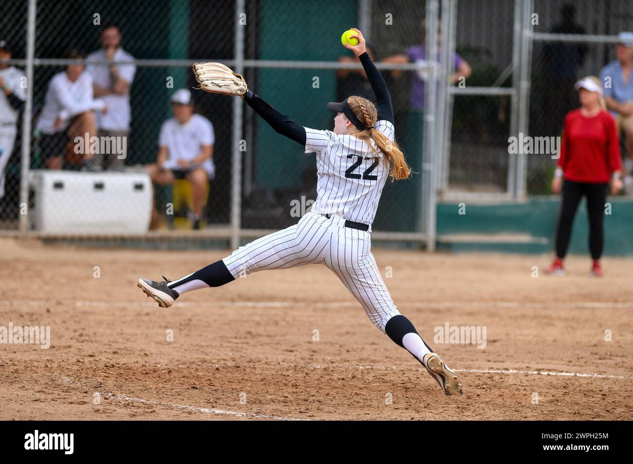 Un joueur de softball est dans Un windup lancant la balle Banque D'Images