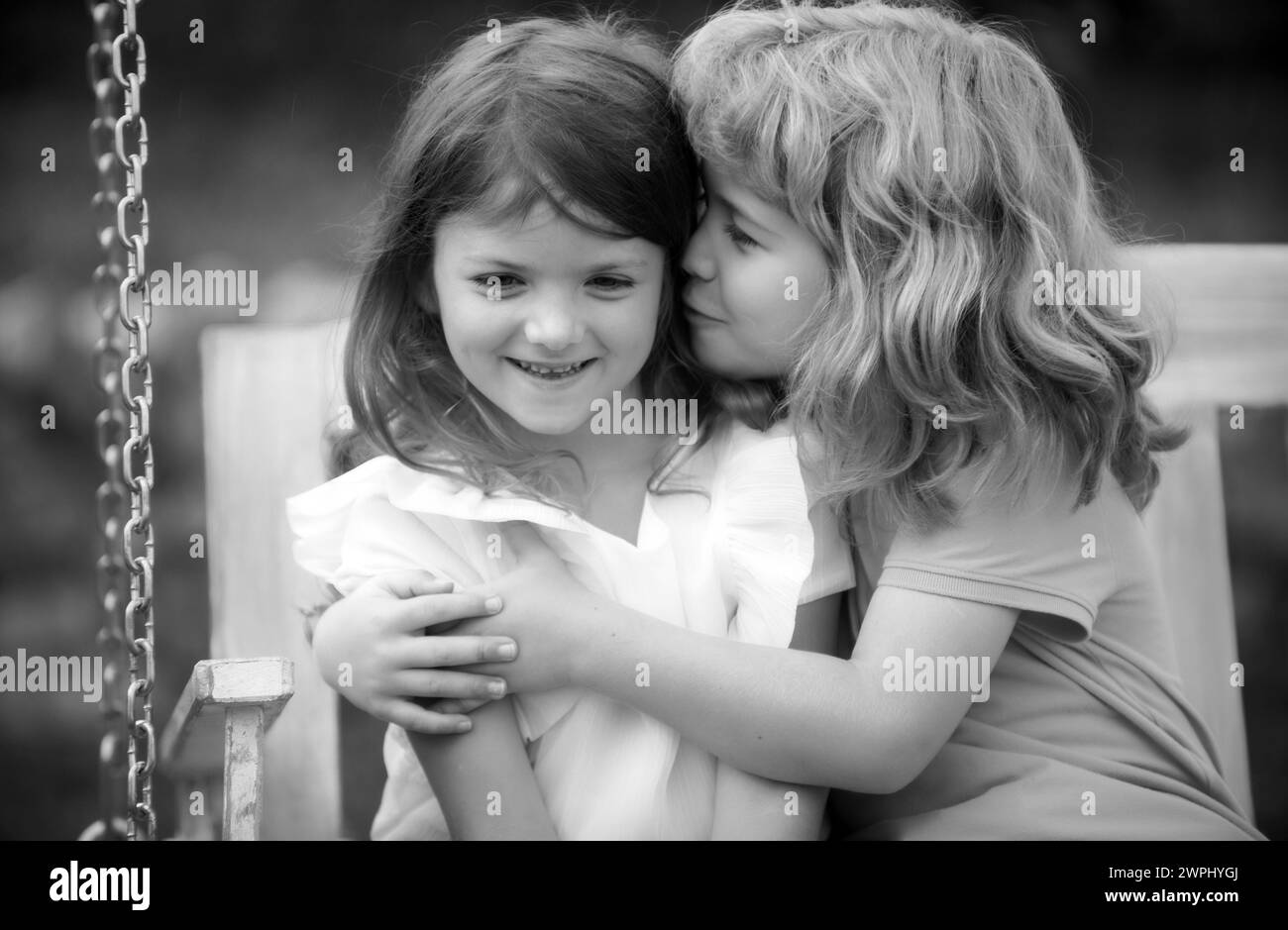 Deux petits enfants s'embrassent et s'embrassent dans le jardin d'été. Couple d'enfants amoureux. Amitié et enfance. Enfants heureux s'amuser à l'extérieur. Enfants Banque D'Images