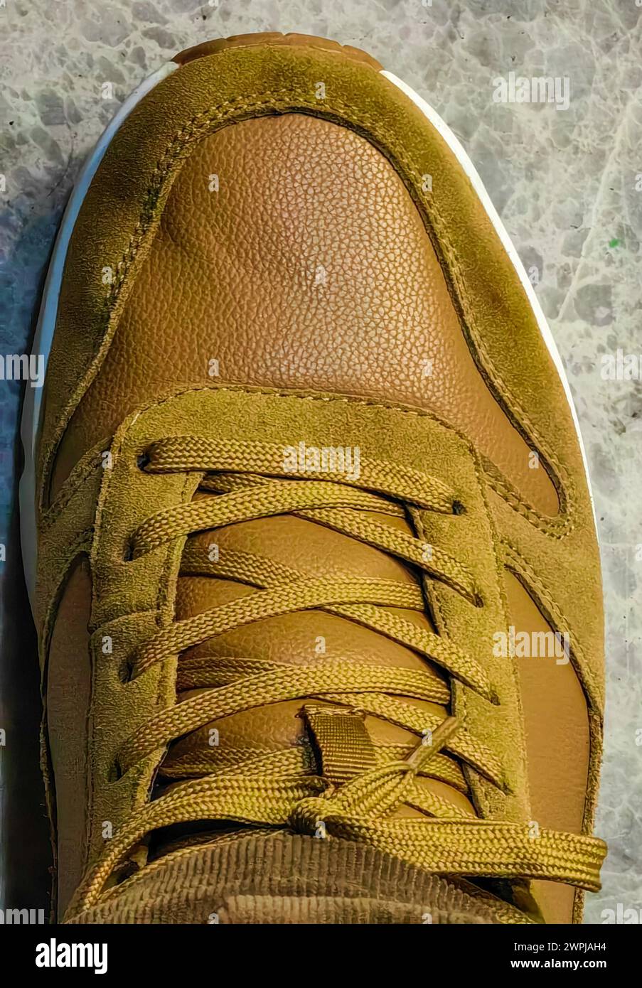 Gros plan élégance. Lacet de chaussure de sneaker en cuir daim jaune marron. Banque D'Images