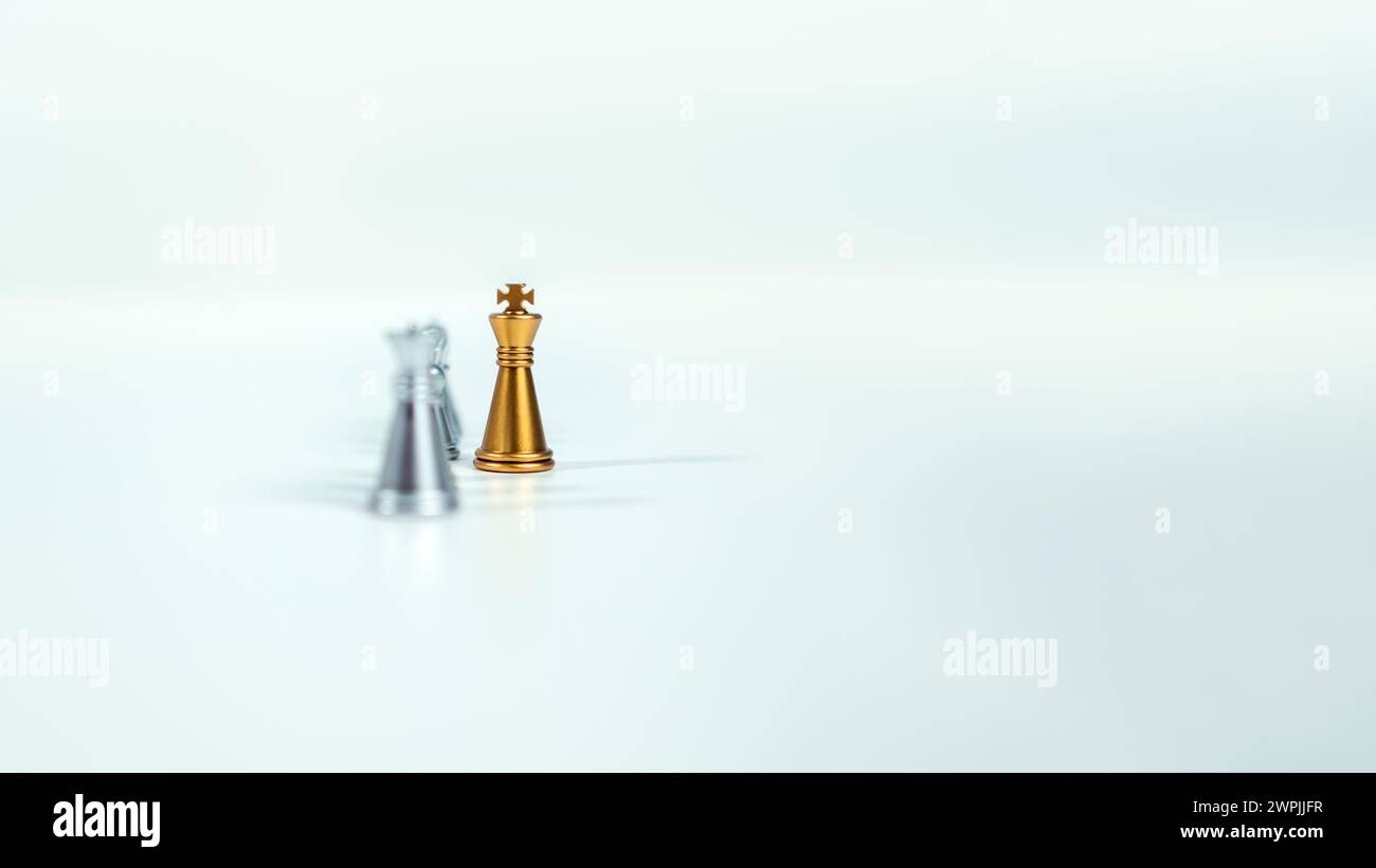 Échecs de roi d'or sur le tableau devant des pièces d'échecs en argent sur fond blanc avec espace de copie, leadership, combattant, direction des affaires, concurrent Banque D'Images