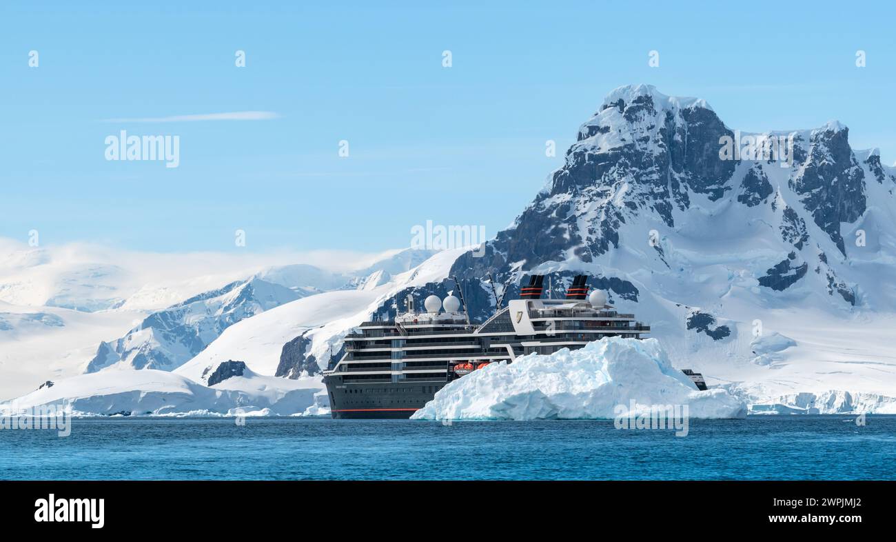 Hanusse Bay, Antarctique - 14 janvier 2024 : navire de croisière Seabourn Pursuit derrière l'iceberg en Antarctique. Banque D'Images