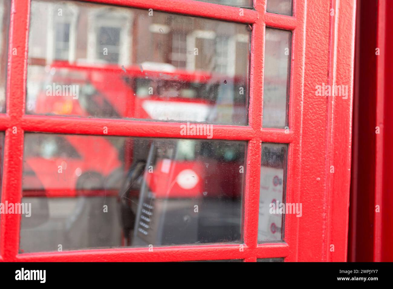Royaume-Uni, Londres, reflet du London bus dans les fenêtres de la cabine téléphonique. Banque D'Images