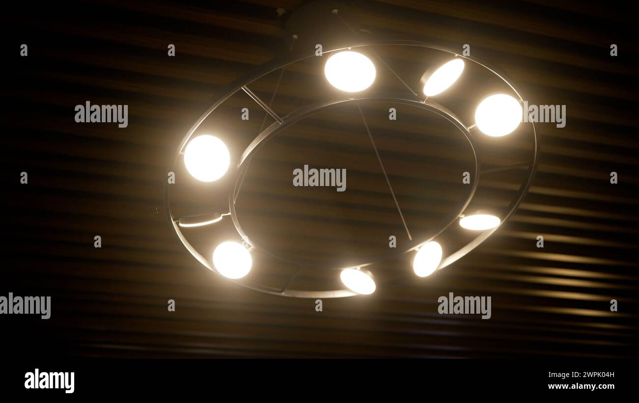 Lustre rond inclus avec des ampoules sur le fond d'une vue de plafond en bois d'en bas. Lustre moderne dans les hôtels. Rond en bois Banque D'Images