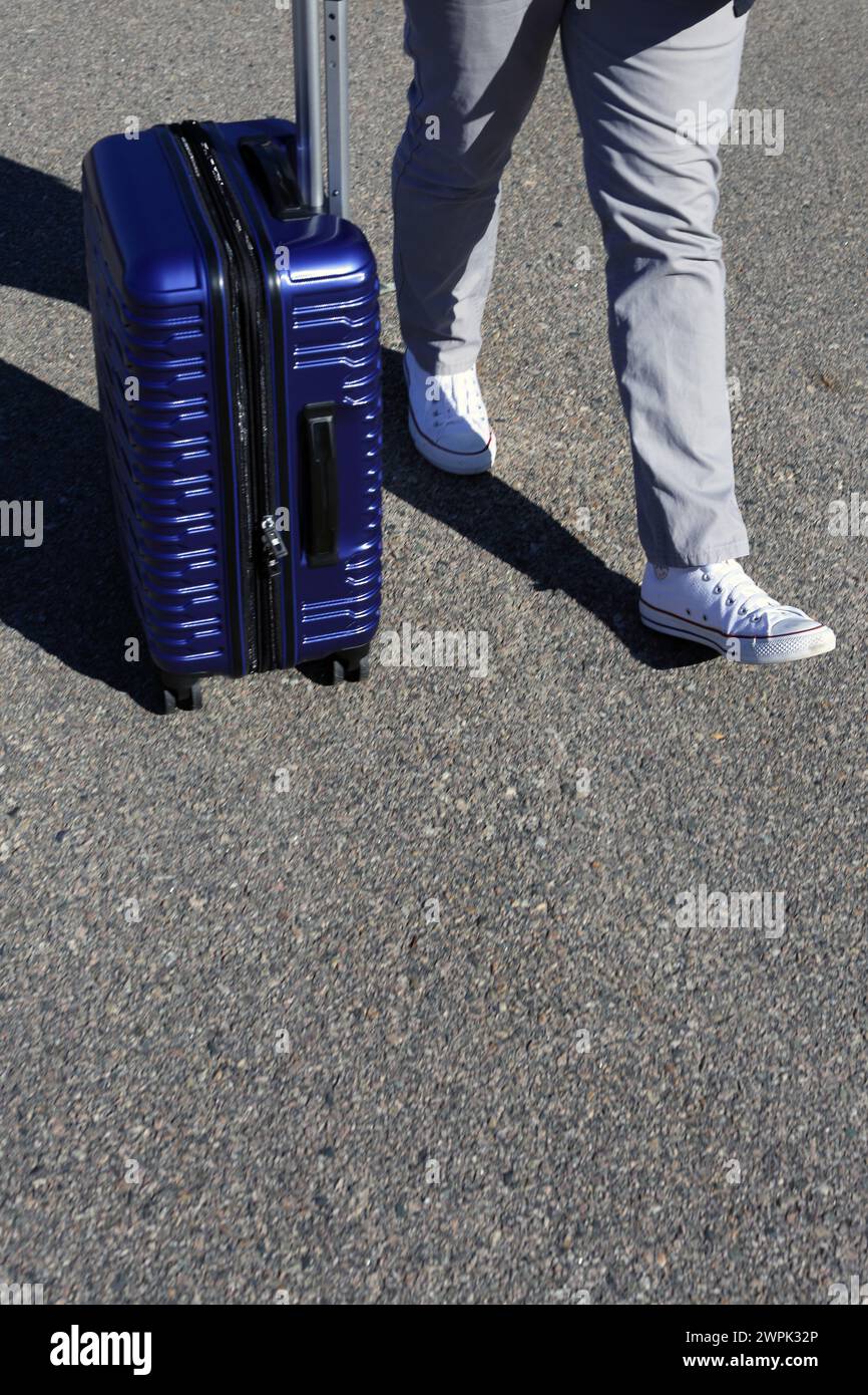 gros plan d'un voyageur portant sa valise roulante. Banque D'Images