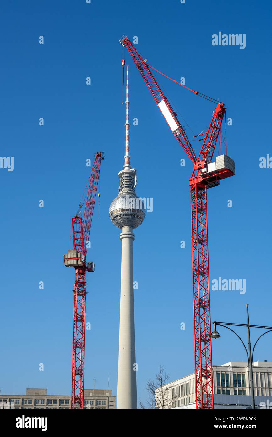 La célèbre tour de télévision de Berlin avec deux grues de construction rouges Banque D'Images