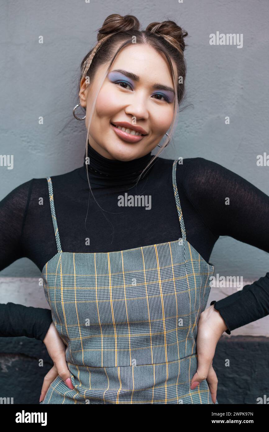 Jeune femme asiatique élégante avec un maquillage moderne et une tenue chic - look urbain confiant avec une touche d'élégance Banque D'Images