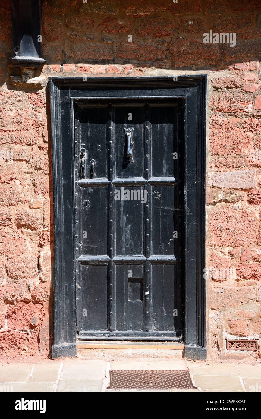 Vieille porte en bois dans un bâtiment le long de la cathédrale à proximité dans le centre-ville, Exeter, Devon, Royaume-Uni, Europe. Banque D'Images