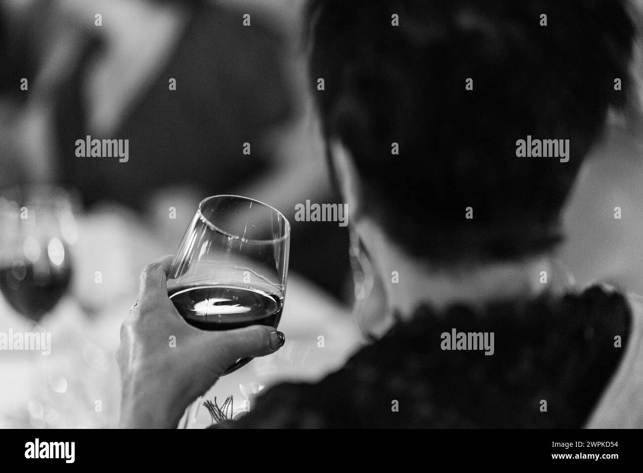 femme buvant du vin à la table du dîner noir et blanc Banque D'Images