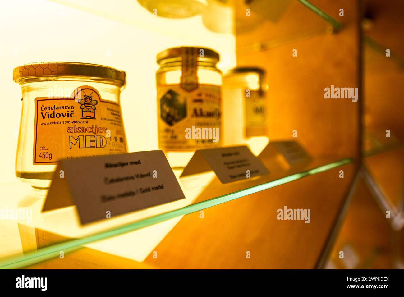 Miel sur vitrine avec un motif en nid d'abeilles en bois et lumière Banque D'Images