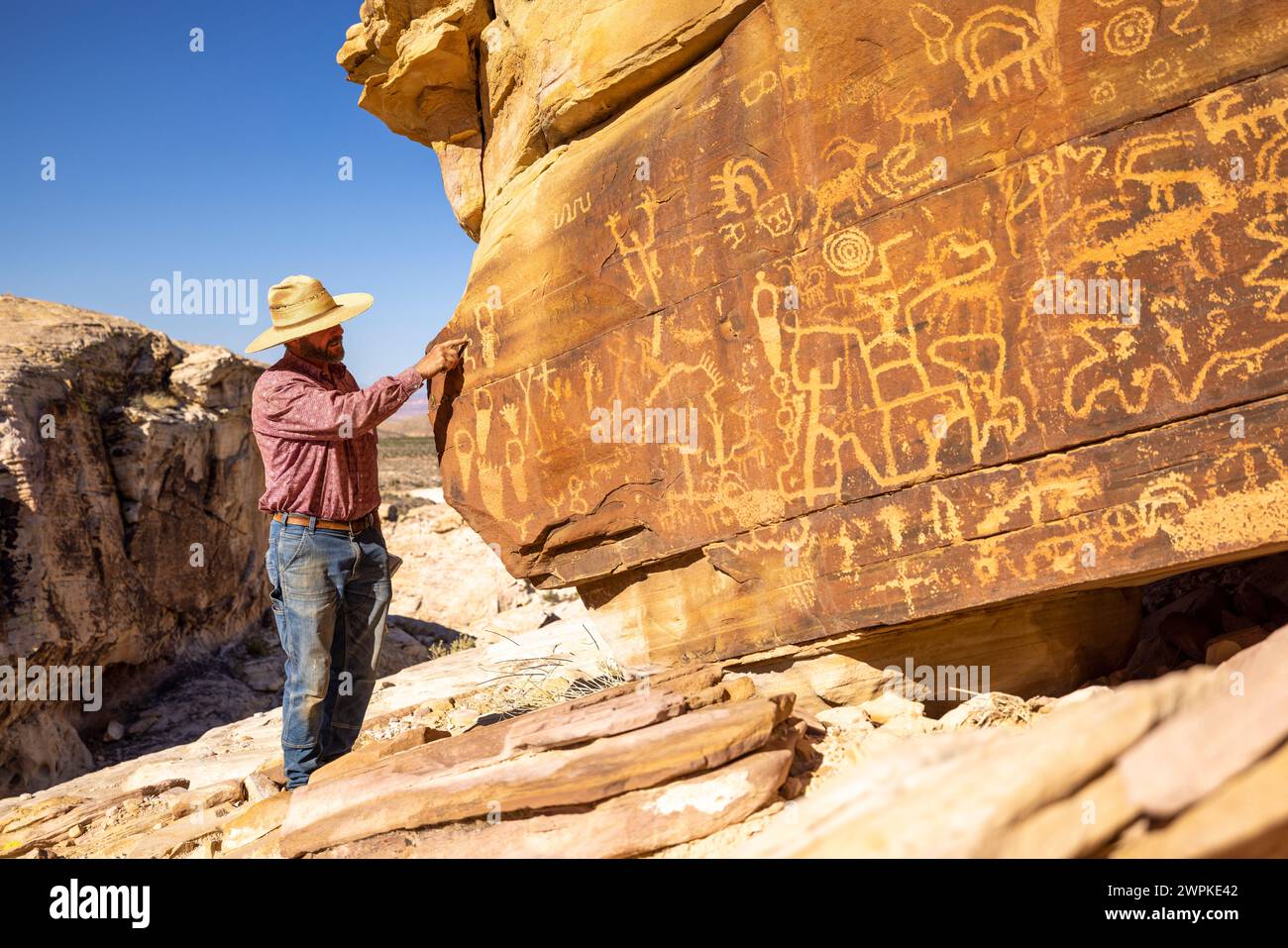 L'homme explique les pétroglyphes dans le monument national Gold butte Banque D'Images